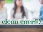 Clean energy sign sits on desk where entrepreneurs are meeting.