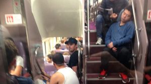 Passengers stand and sit in aisles on a train travelling through the Blue Mountains. 