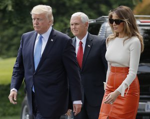 Vice President Mike Pence, center, watches as President Donald Trump and first lady Melania Trump walks across the South Lawn of the White House in Washington, Friday, May 19, 2017