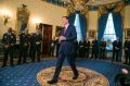 James Comey walks across the room to greet the President after being spotted against the far wall. 