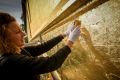 Joanna Buckley applies gold leaf to the Providence building at Abbotsford Convent.