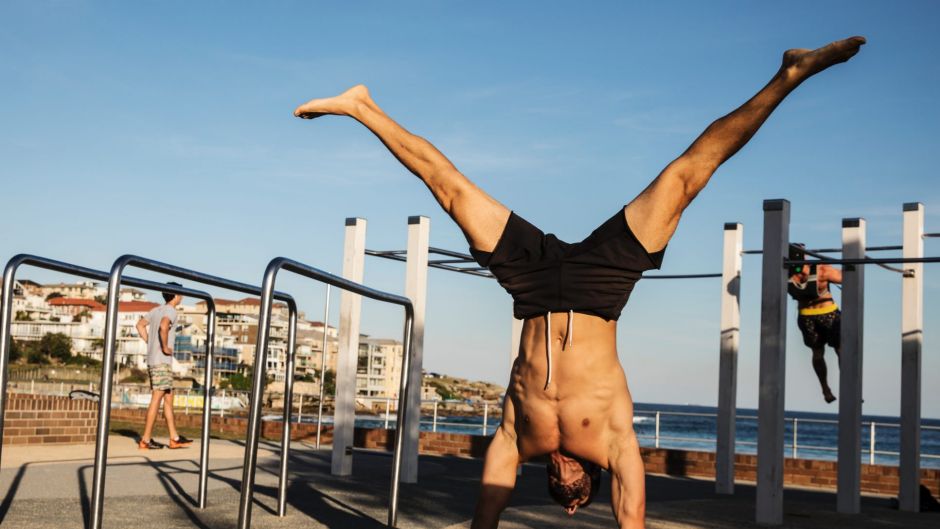 A man enjoys the autumn sun at Bondi Beach while exercising on the open air gymnasium equipment, on May 17, 2017 in ...