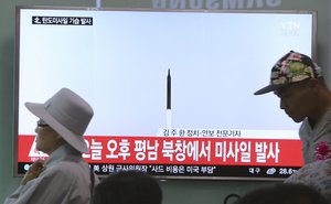 People walk by a TV news program showing a file image of a missile launch conducted by North Korea, at the Seoul Railway Station in Seoul, South Korea, Sunday, May 21, 2017.