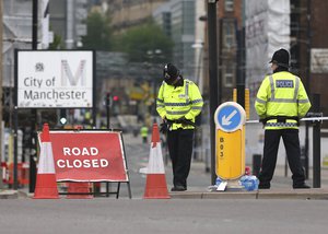 Police officers stand guard close to Victoria Railway Station in Manchester, Britain, Wednesday, May 24, 2017, after a suicide attack at an Ariana Grande concert.