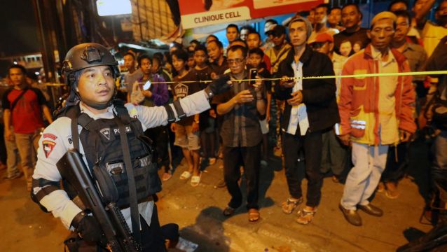 Police officers clear the scene after an explosion near a bus stop in the Kampung Melayu area of Jakarta.