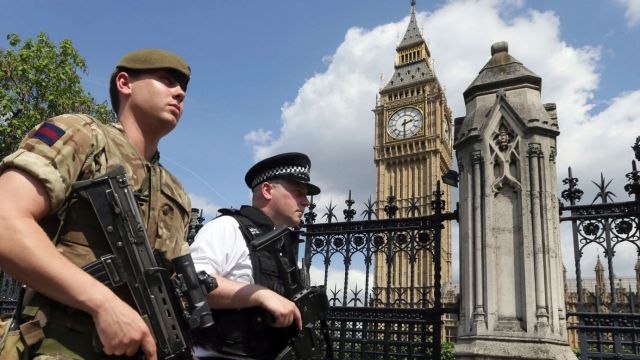 A member of the army joins police officers in Westminster, London.