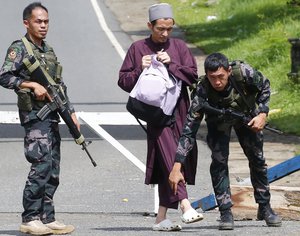 Government troops frisk a Muslim man at a checkpoint leading to Marawi city three days after Muslim militants lay siege in the city in southern Philippines Thursday, May 25, 2017.