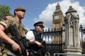 A member of the army joins police officers in Westminster, London.