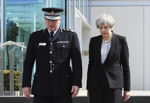 Britain's Prime Minister Theresa May walks with Greater Manchester Police chief constable, Ian Hopkins, at Greater Manchester Police headquarters in Manchester, England, Tuesday May 23, 2017, after a 23-year-old man was arrested in connection with Monday's Manchester concert bomb attack.