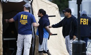 A man is taken into custody by FBI agents Wednesday, May 17, 2017, in Los Angeles.