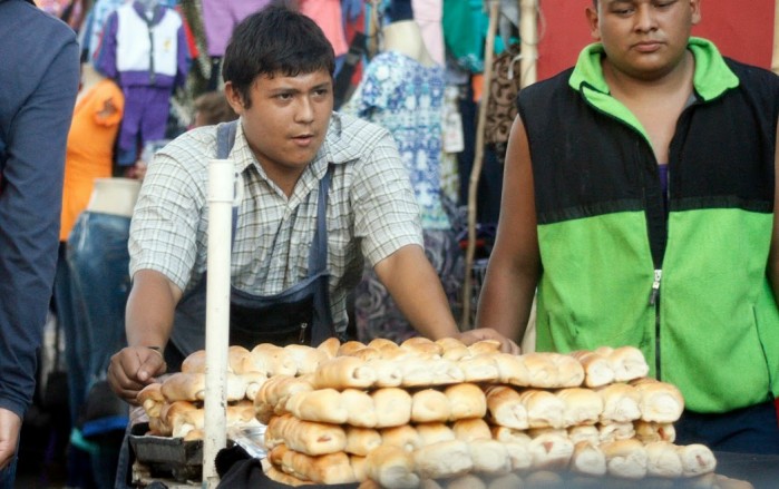 Joven vendiendo pan de manera informal