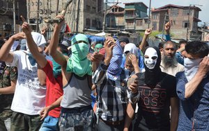 Masked Kashmiri protesters hold bricks as they shout freedom slogans in Srinagar, India, Saturday, May. 27, 2017. One civilian was killed and dozens of others injured Saturday after massive anti-India protests and clashes erupted in Indian-controlled Kashmir following the killing of a prominent rebel commander and his associate in a gunbattle with government forces in the disputed region.