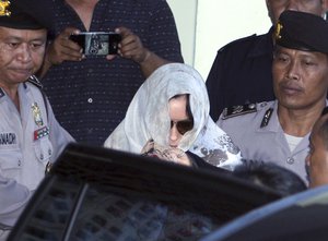 Australian drug smuggler Schapelle Corby covered her head with a scarf gets on a car as she leaves the parole office in Bali, Indonesia, Saturday, May 27, 2017.