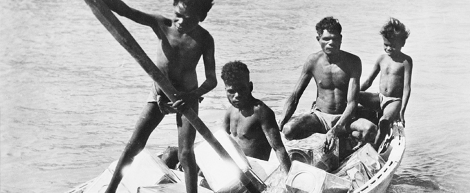 Image : Aboriginal men and boys row ashore supplies for an RAAF base in North Australia