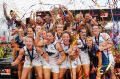 Victors: Adelaide players celebrate with the premiership cup. 