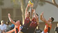 ALICE SPRINGS, AUSTRALIA - MAY 27:  James Harmes of the Demons marks over Steven May of the Suns during the round ten ...