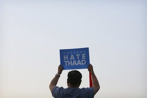 A South Korean protester holds up a card during a rally to oppose a plan to deploy the advanced U.S. missile defense system called Terminal High-Altitude Area Defense, or THAAD, near U.S. Embassy in Seoul, South Korea, Saturday, April 29, 2017.