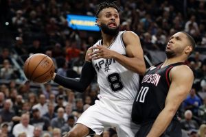 San Antonio Spurs' Patty Mills (8) goes up to make a pass over Houston Rockets' Eric Gordon (10) during the second half ...