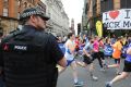 An armed police officer stands at the start of the Great Manchester Run on Sunday. 