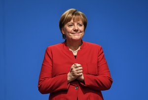 German Chancellor and Chairwomen of the CDU, Angela Merkel, holds hands after her speech as part of a general party conference of the Christian Democratic Union (CDU) in Essen, Germany, Tuesday, Dec. 6, 2016.