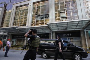 Policemen walks past a still smoldering part of a hotel at the Resorts World Manila complex, early Friday, June 2, 2017, in Manila, Philippines. A gunman stormed a mall-casino complex, torched gambling tables and stuffed a backpack with casino chips before fleeing but was found dead of an apparent suicide in an adjacent hotel early Friday, authorities said.(AP Photo/Aaron Favila)