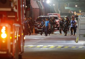 Armed security officers walk outside a hotel at the Resorts World Manila complex, early Friday, June 2, 2017, in Manila, Philippines.