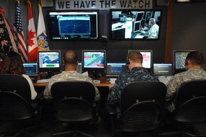 File - Volunteers monitor phones and computers while tracking Santa Claus at the NORAD Tracks Santa Operations Center on Peterson Air Force Base, Colorado, December 24.