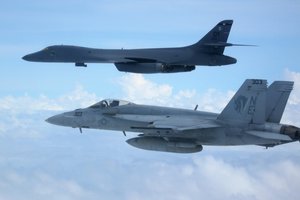 File - A B-1B Lancer Bomber and an F/A-18E Super Hornet fly over the aircraft carrier USS Carl Vinson as it transits the Philippine Sea, Feb. 14, 2017.