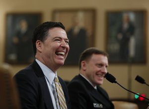 FBI Director James Comey, left, joined by National Security Agency Director Michael Rogers, right, react to a lawmaker's remark on Capitol Hill in Washington, Monday, March 20, 2017, as they testified before the House Intelligence Committee hearing on allegations of Russian interference in the 2016 U.S. presidential election.