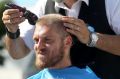 Melbourne City's Luke Brattan having his hair cut for the World's Greatest Shave charity at AAMI Park on Wednesday.