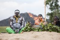 Djakapurra Munyarryun, Kevin Yunipingu and Tina Dhamarrandji sit near a ceremonial fire at the Lorrkkon ceremony