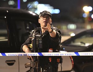 An armed Police officer gestures after an incident in central London, Saturday, June 3, 2017.