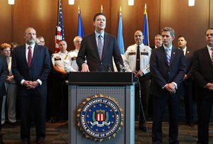 File - FBI Director James Comey, backed by law enforcement personnel and prosecutors, addresses a news conference Tuesday, June 17, 2014 at the FBI Minneapolis field office in Brooklyn Center, Minn.