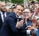 Emmanuel Macron, left poses for a selfie after a ceremony at the Arc de Triomphe.