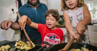 Will Richey is working with his son, Alston, on proper knife skills, while his daughter, Marie, handles the seasoning and mixing. Photo: Amy Jackson