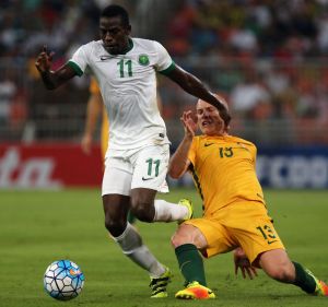 Saudi midfielder Abdulmalek Al-Khaibri breaks free of Socceroo Aaron Mooy in the Jeddah qualilfying leg in October. 