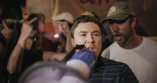 At the May 14 candlelight demonstration in Robert E. Lee Park, right-wing activist Jason Kessler was arrested for disorderly conduct for refusing to leave the park and inciting with a bullhorn. Kessler says protestors blocked him from leaving. Photo by Eze Amos