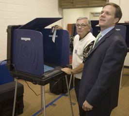 Election judge Jeff Moore watches Colorado 7th Congressional District candidate for the House of Representatives, Rick O'Donnell, right, call his friends and family over to the voting booth at Foothills Elementary School to see how his name appears on the ballot Tuesday, Nov. 7, 2006 in Lakewood, Colo.