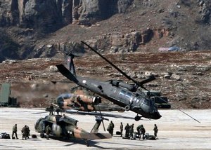 A Turkish military helicopter takes off as elite troops board another helicopter to head into Iraq to participate in a combat mission against Kurdish rebels, in Cukurca at Turkey-Iraq border in this Feb. 27, 2008 file photo. Turkey's Chief of Staff Gen. Yasar Buyukanit threatened Monday, March 3, 2008, to send the armed forces into Iraq again to "teach further lessons" to Kurdish rebels and said a recent incursion was a success in part because of harsh winter conditions. 