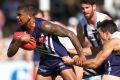 PERTH, AUSTRALIA - MARCH 04: Bradley Hill of the Dockers attempts to slip from a tackle by Levi Greenwood of the Magpies ...