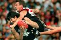 Rough stuff: The Bombers' Mark Thompson crashes into Blues captain Stephen Kernahan.