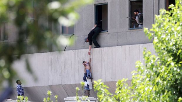 A child is lowered from a window in the Iranian Parliament building following the attack.