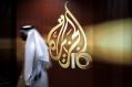 A Qatari employee walks past the logo of Al Jazeera in Doha, Qatar. 