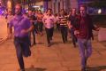 A man holds his beer while people flee terror attacks in London on Saturday. 