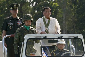 Philippine President Rodrigo Duterte, right, reviews the troops with Army Chief Lt. Gen. Glorioso Miranda, left, during the 120th anniversary celebration of the Philippine Army Tuesday, April 4, 2017 at Fort Bonifacio in suburban Taguig city, east of Manila, Philippines.