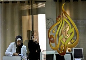 Employees of the Arab news station Al-Jazeera pack equipment and talk on the phone at the station's offices in the West Bank city of Ramallah, Wednesday, July 15, 2009.