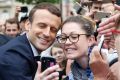 Emmanuel Macron, left poses for a selfie after a ceremony at the Arc de Triomphe.