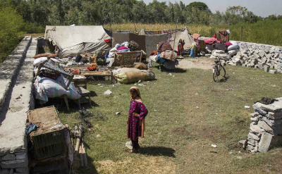  A girl stands with her family's possessions which they've brought to Afghanistan's Nangarhar province