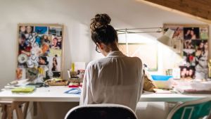 Young businesswoman at her desk in home studio.