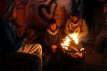 Palestinians, who get only several hours of electricity a day, sit around a fire outside their home in Gaza City. 